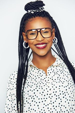 Studio portrait of confident smiling woman wearing glasses