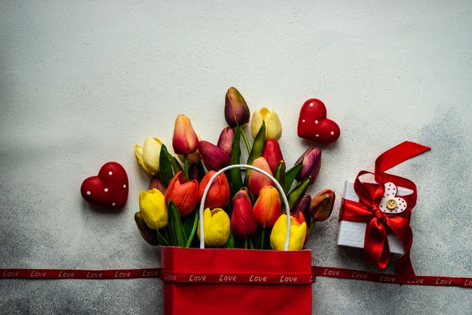 Red bag of tulips with present and heart ornaments