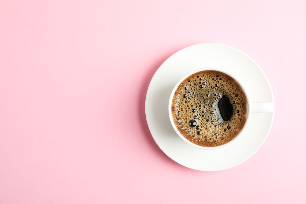 Cup of coffee on color background, space for text
