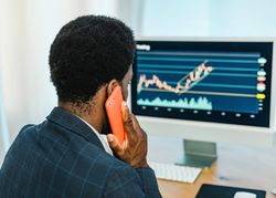Black male trader talking on smartphone