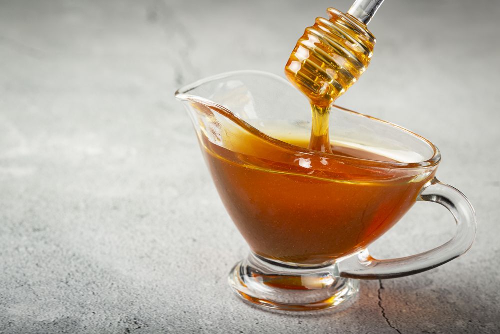 Honey in glass bowl on the table.