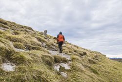 Man walking on hill near valley