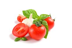 Fresh cherry tomatoes with basil and garlic isolated on blank background. Ripe vegetables