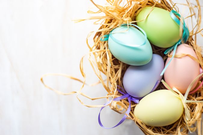 Easter card concept with pastel eggs in hay with space for text