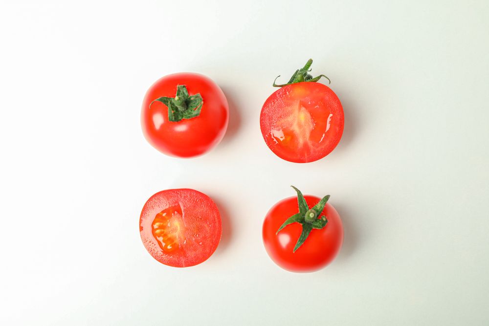 Flat lay composition with fresh cherry tomatoes on plain background, space for text. Ripe vegetables