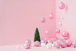 Baubles in a variety of pink shades in corner of pink room with Christmas tree
