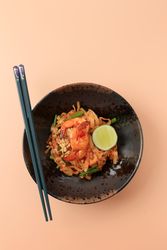 Top view of spicy pad Thai in dark bowl
