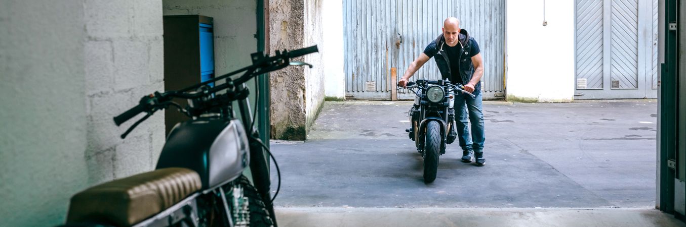 Biker taking motorbike to the garage