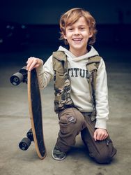Boy with skateboard on knees