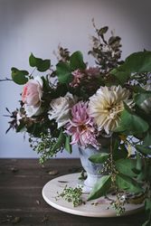 Composition of flowers and plants in vintage vase on board