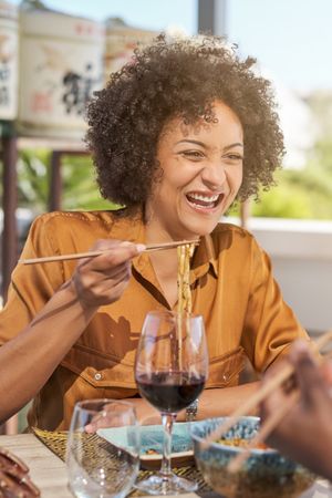 Smiling Hispanic woman eating in restaurant