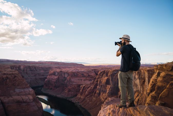 Bearded traveler taking photos of canyon