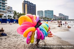 Street seller holding inflatable rings at the beach in Cartagena, Bolivar,  Colombia 4AowY0