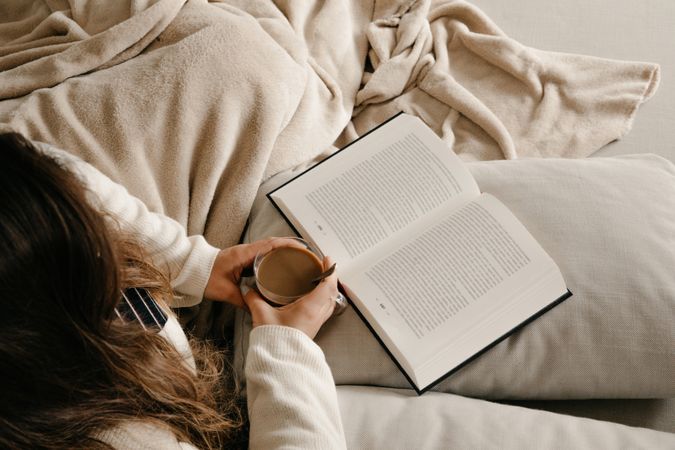 Person reading a book on the bed