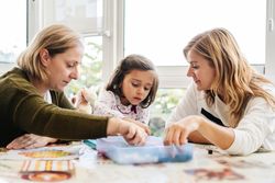 Woman playing board game with daughter and granddaughter
