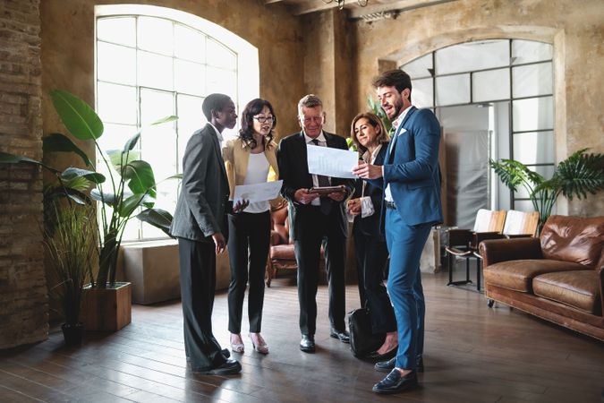 Multi-ethnic corporate business people discussing a project presentation gathered in the boardroom