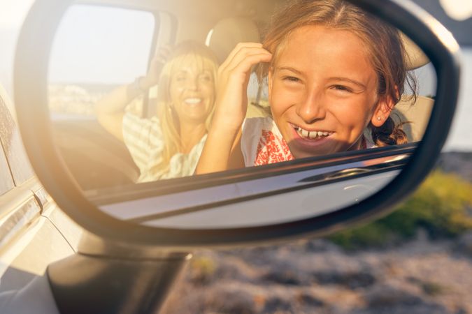 Mirror of a car with the image of a mother and daughter looking