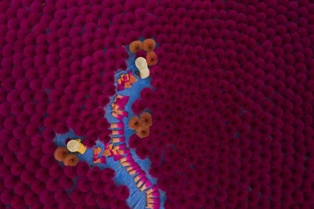 Top view of Vietnamese workers surrounded by purple incense sticks in Quang Phu Cau, Hanoi, Vietnam