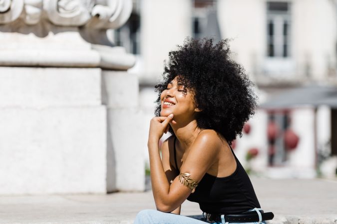 Black female siting on stairs outdoors