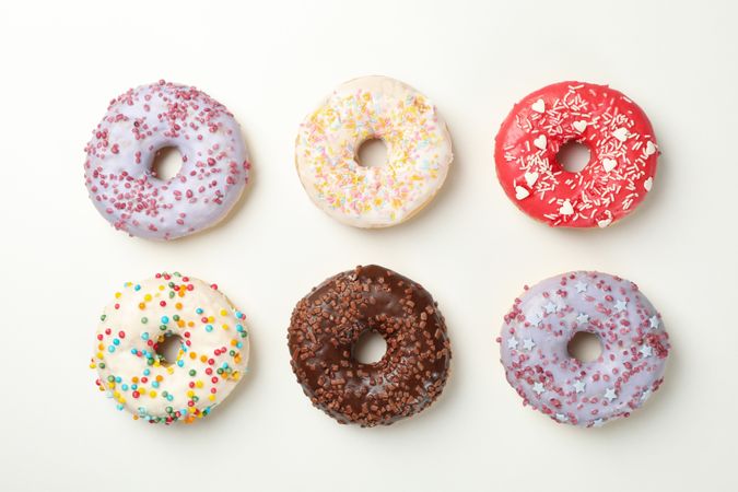 Flat lay with tasty donuts on plain background
