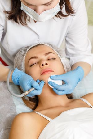 Woman having facial beauty treatment with instrument on her chin