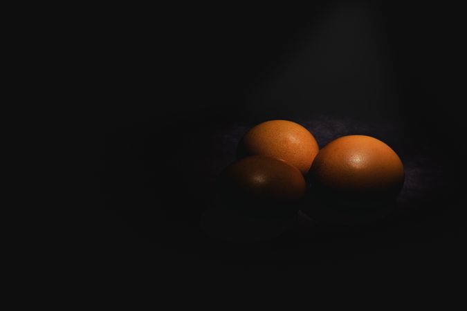 Raw eggs on dark background