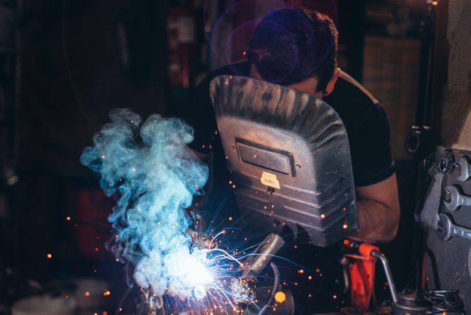 Professional welder in mask welding metal