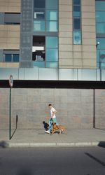 Man running and playing with his dog Boxer in a park