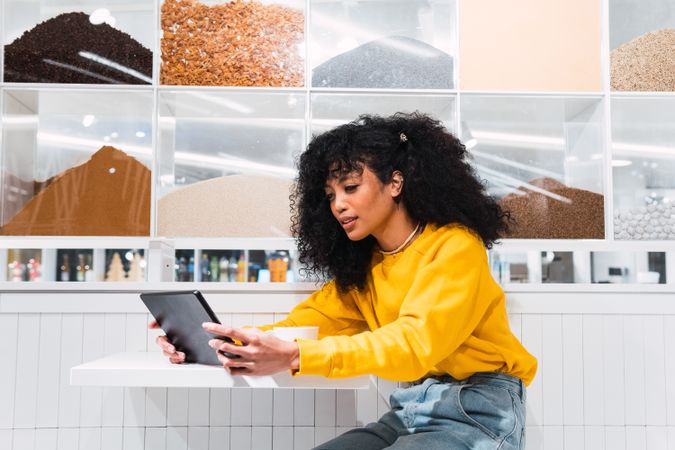 Black female using tablet against wall