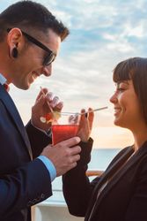 Young man and woman drinking juice from one glass