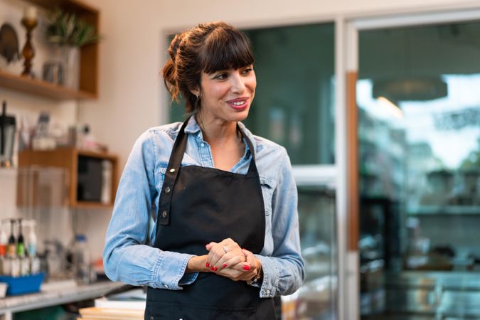 Portrait of happy coffee shop owner welcoming patrons