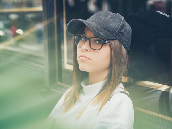 Young woman standing against glass