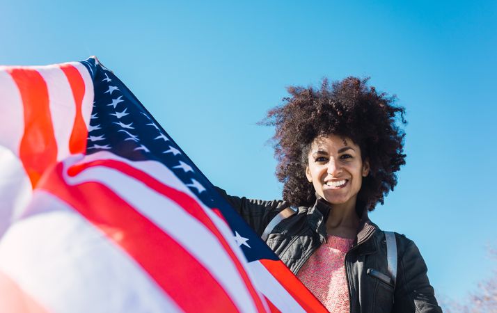 Black woman with afro hair and an american flag