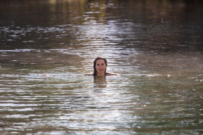 Woman swimming and looking at camera in lake