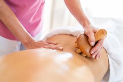 Back of client lying on table during osteopathy session in clinic