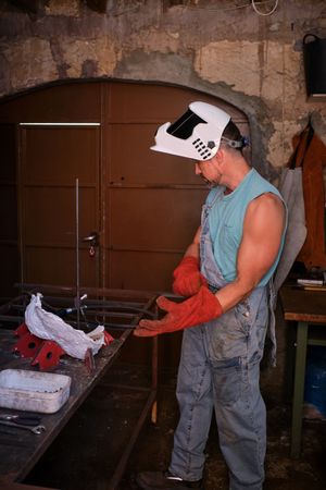 Professional worker wearing gloves in welding workshop