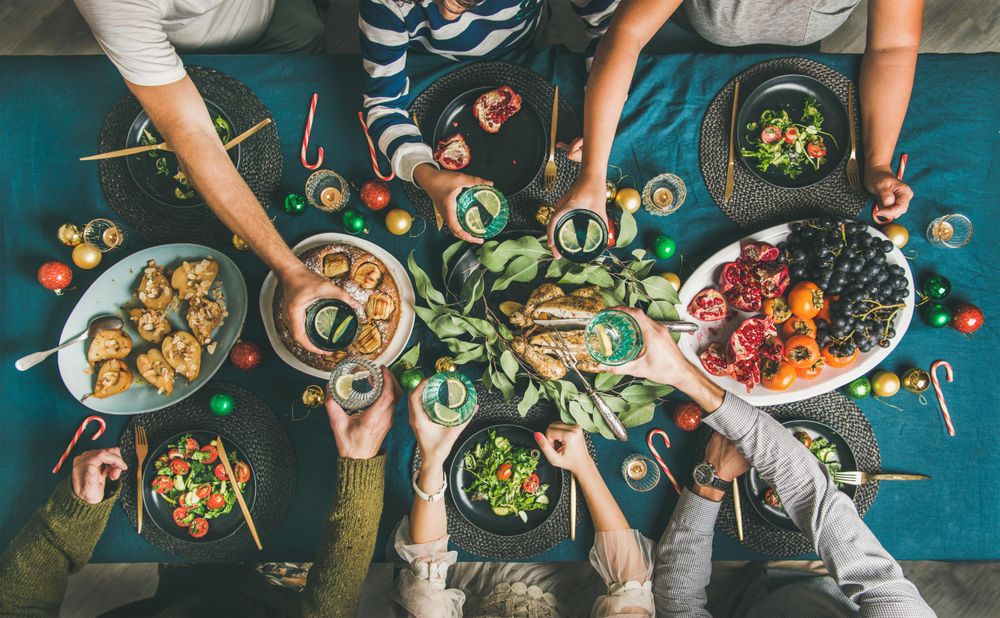 Group toasting at festive table with candy canes and roasted pears
