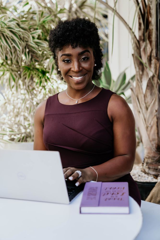 Woman in purple dress working on her laptop