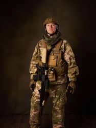 a young military soldier with automatic airsoft rifle with telescopic vision