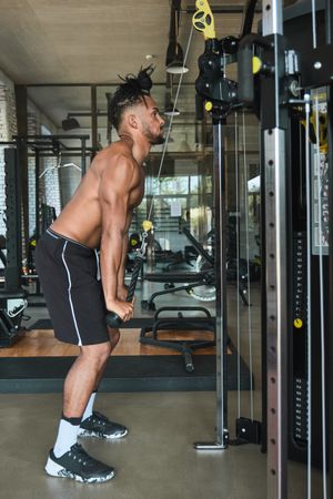 Black guy using exercise machine in gym