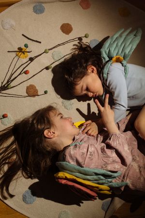 Little girls in angel costume sleeping over soft mat