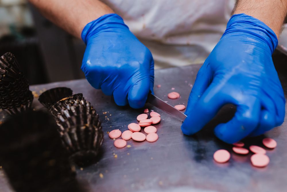 Anonymous baker decorating small cakes