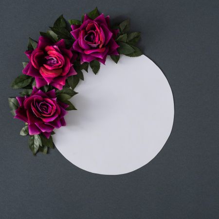 Purple flowers and leaves on gray background with paper card