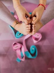 Faceless woman practicing yoga on pink mat