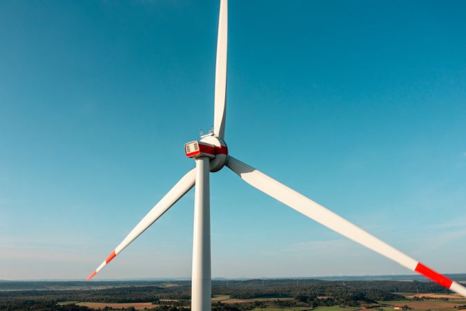 Drone aerial view with a wind turbine minimalist on a clear blue sky, in Germany