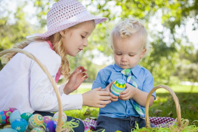 Cute Young Brother and Sister Enjoying Their Easter Eggs Outside