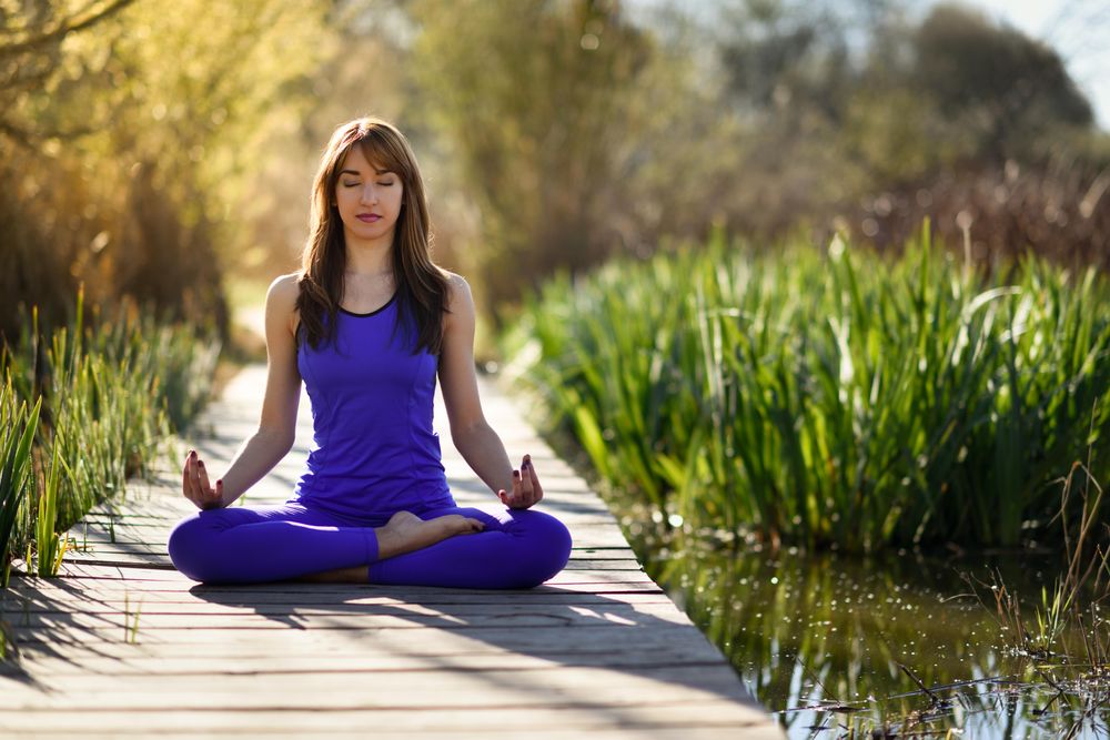 Female wearing purple sport clothes in lotus figure