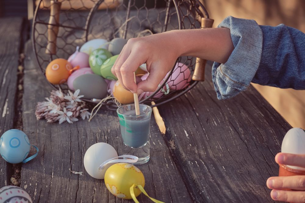 Easter eggs painted by kid on wooden table