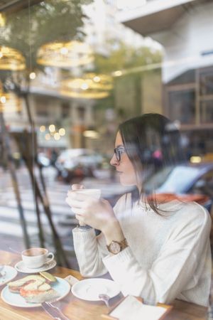 Young woman drinking hot beverage in cafe