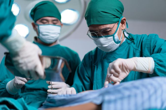 Surgeons working on patient in hospital theatre